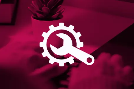 An icon featuring a wrench and gear, symbolizing tools and settings, is displayed against a pink background. The image conveys themes of maintenance, repair, or settings, possibly related to technology or workspace organization. A small potted plant is also present in the background.