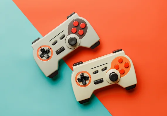 Two retro-style video game controllers are displayed on a split-color background, one half light blue and the other half orange. Each controller features a directional pad, buttons in varying colors, and a joystick, emphasizing a playful gaming theme.