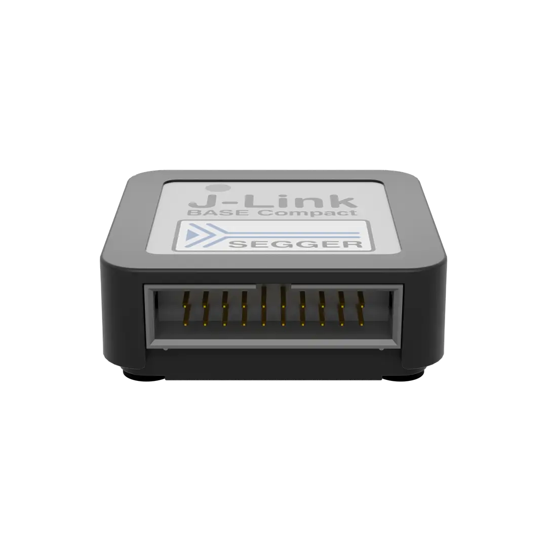 J-Link BASE Compact device by SEGGER, featuring a rectangular gray housing. The front has an opening with several metal pins inside. The top has the product name and company logo printed on a white background, indicating it is a programming and debugging tool for embedded systems.