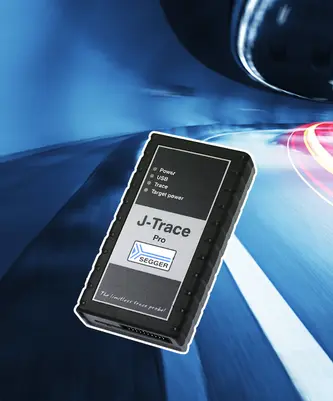 Image of a SEGGER J-Trace Pro device, a black rectangular hardware tool featuring labels for "Power," "USB," "Trace," and "Target power." The product is designed for programming and debugging software, set against a blurred background suggesting speed and technology.