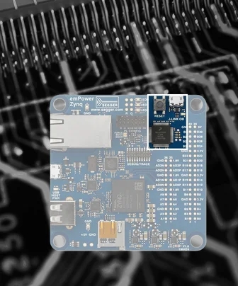 A blue circuit board identified as "emPower Zynq" featuring various electronic components, ports, and labels. The board is central in the image against a blurred dark background, highlighting its design and connections.
