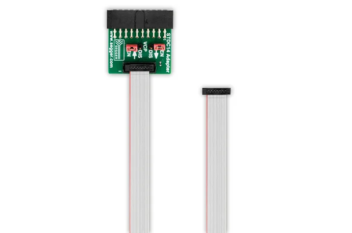 Image shows a STDC14 Adapter with a green circuit board featuring connection points and labels for "EN," "DIS," and "V0." A flexible ribbon cable is connected to the adapter, with the other end exposed and unconnected. The background is plain white.