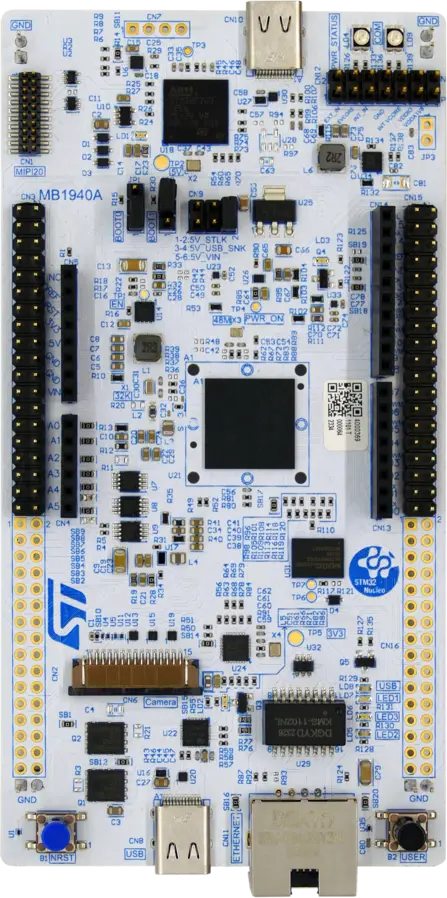 A top-view image of a development board featuring various components such as microcontrollers, connectors, and ports. The board is predominantly blue with printed circuit markings, including power indicators and multiple pin headers for interfacing with other devices.