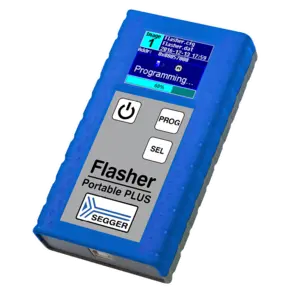 A blue, handheld programming device labeled "Flasher Portable PLUS" is shown. The device features a small screen displaying programming status and file information, along with three buttons: a power button, "PROG," and "SEL." The surface has a textured grip for ease of handling.