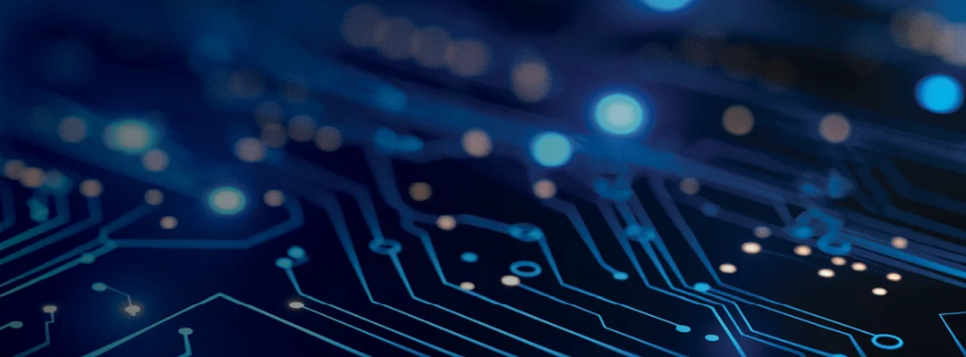Close-up of an intricate circuit board featuring glowing blue lines and dots. The background is dark, enhancing the luminous elements of the circuitry, creating a technological and modern visual effect.