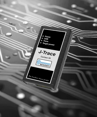 A black and white device labeled "J-Trace Cortex-M" sits on a textured circuit board background. The device features indicators for "Power," "USB," "Trace," and "Target power," with the SEGGER logo below. The tagline "The limitless trace probe" is printed at the bottom.