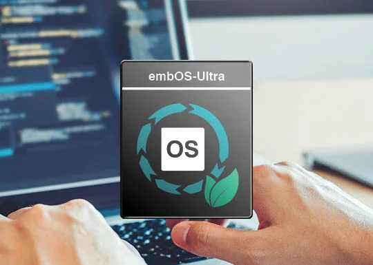 A person’s hands are seen on a keyboard, with lines of code displayed on a nearby screen. Overlaying the image is a logo for "embOS-Ultra," featuring a circular design with arrows and green elements, indicating a focus on operating system functionality.