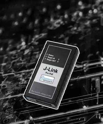 A black device labeled "J-Link Pro PoE" with indicator lights for "Status," "Target IN," and "Target OUT." It is used for remote debugging in electronics. The background features subtle circuit patterns, emphasizing the device's technological context.