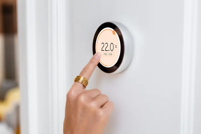 Finger touches thermostat