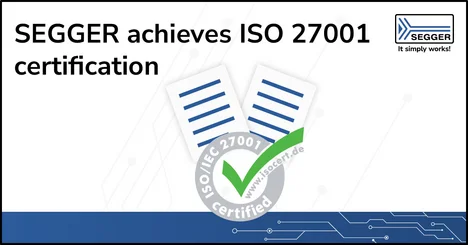 Image features the text "SEGGER achieves ISO 27001 certification." Accompanying this is an illustration of two documents with checkmarks, symbolizing certification. The corner displays the SEGGER logo. The overall design conveys a message of accomplishment in achieving ISO 27001 for information security management.