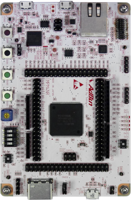 A top-down view of a circuit board featuring various electronic components, connections, and a prominent microcontroller at the center. The board has multiple ports, buttons, and surface-mounted parts, indicating functionality for development or prototyping in electronics.