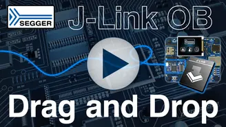 Image depicting a J-Link OB device prominently displayed against a circuit board background. The phrase "Drag and Drop" is featured at the bottom, while a play button is centrally located, suggesting the presence of a video or tutorial.