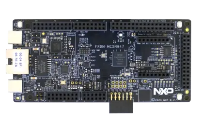 Image of a black circuit board labeled "FRDM-MCXN947" with various electronic components, including integrated circuits, capacitors, and pin headers. The board includes multiple connectors on the sides and a prominent "NXP" logo. It appears to be used for development or prototyping in electronics.