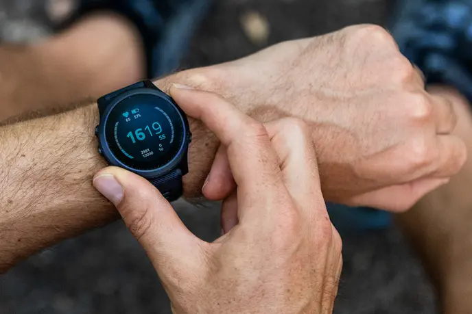 Hand pressing a button on smartwatch